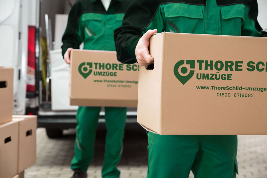 Thore Schild Umzüge - Transport Zwei Mitarbeiter von Thore Schild Umzüge tragen zwei Umzugskartons.