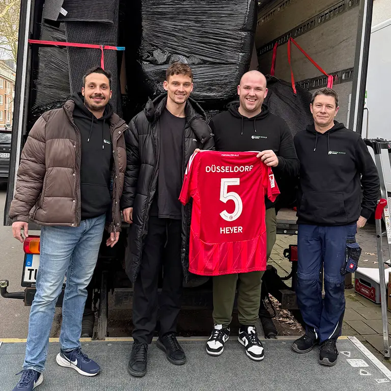 Gruppenfoto mit dem Team von Thore Schild Umzüge und dem Fussballer von Fortuna Düsseldorf Moritz Heyer.